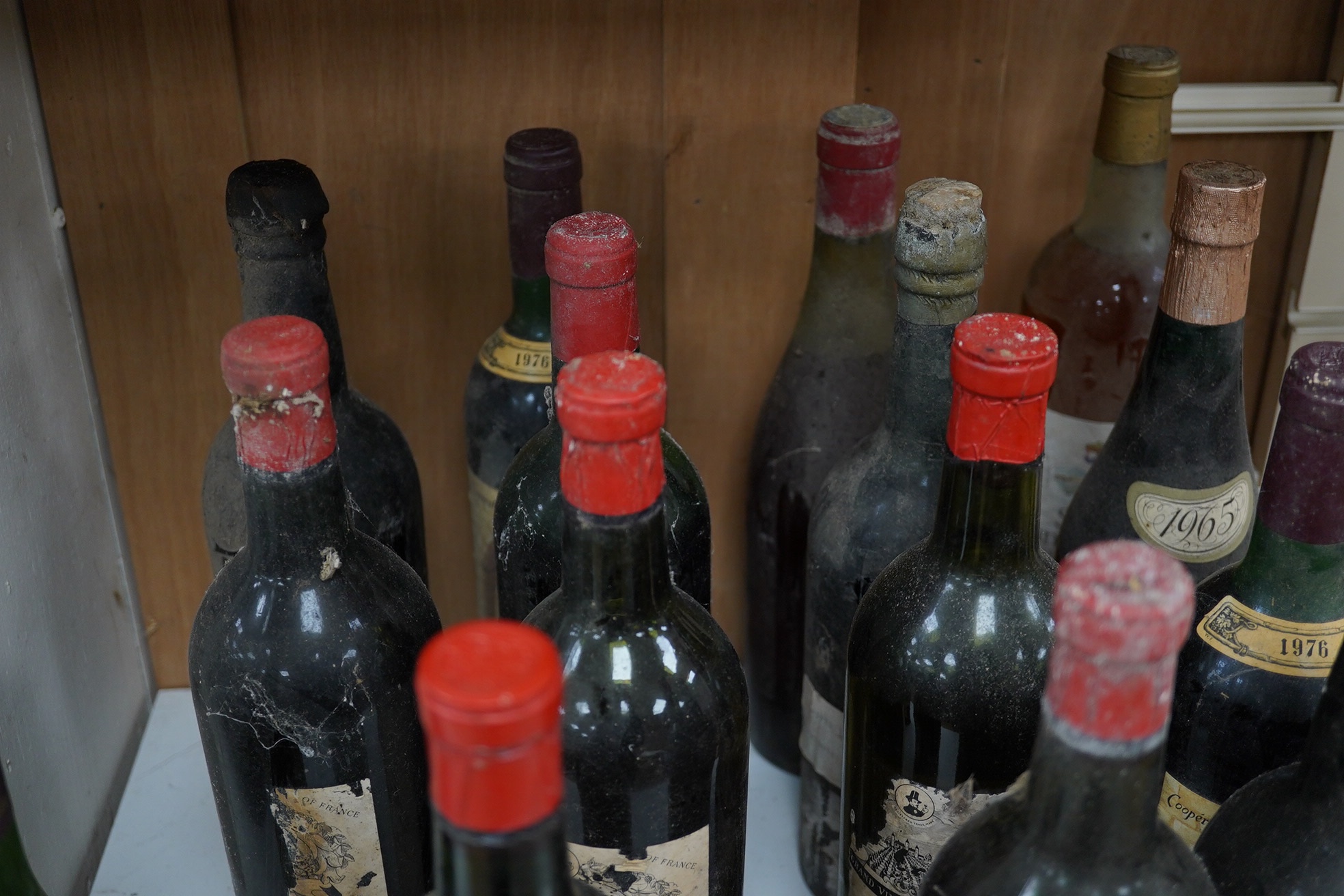 Fifteen bottles of wine and fortified wine, including; a Sandeman 1963 port, four bottles of Chateau La Rose Capbern 1953, a 1976 Madiran Cuvee de la Confrerie, etc. Condition - poor to fair, storage history unknown